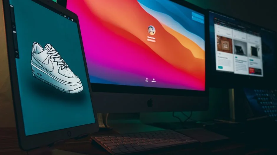 A bright desk arrangement with a design book, laptop, and creative tools, perfect for sparking inspiration.